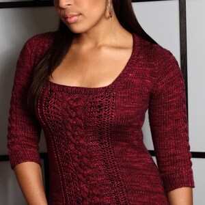 May include: A maroon sweater with a cable knit design and a scoop neck.