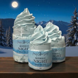 Puede incluir: Tres tarros de manteca corporal batida con una textura azul claro arremolinada, etiquetados como "Nordic Night". Los tarros son transparentes con etiquetas azules y blancas, sobre un paisaje invernal con luna llena y árboles nevados.