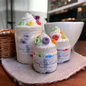 Op de afbeelding: Drie potten met geklopt lichaamsboter met een graan-thema. De potten zijn gelabeld "Jersey Shore Scents" en hebben verschillende maten: 8 oz, 2 oz en 4 oz. De geklopt lichaamsboter is bedekt met kleurrijke graanringen.