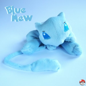 May include: Blue plush toy of the Pokemon Mew, with a long tail. The toy is lying on a light blue surface. The text "Blue Mew" is written in white letters on a blue background in the top left corner of the image.