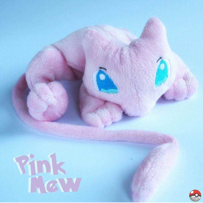 May include: Pink plush toy of the Pokemon Mew. The toy has a long tail and blue eyes. The text "Pink Mew" is written below the toy.