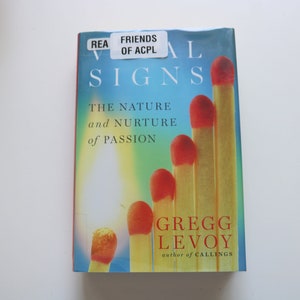 May include: A book titled "Vital Signs: The Nature and Nurture of Passion" by Gregg Levoy, author of "Callings". The cover features a blue, green, and yellow background with a row of lit matches.