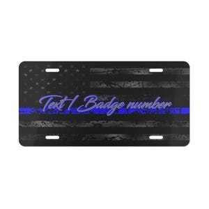 May include: Black and white American flag license plate with a blue line and the text "Text | Badge number".
