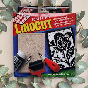 May include: A linocut printing kit with a red, white and black design. The kit includes a linoleum block, a carving tool, a roller and black ink. The text on the box reads "ESSDEE LINOCUT Taster Kit".