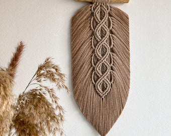 Gran colgante de pared de macramé beige con forma de hoja y plumas, estilo bohemio.