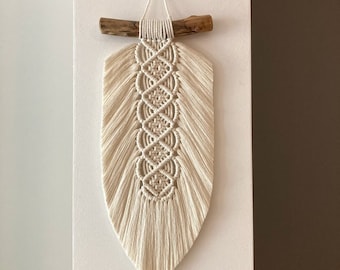 Gran colgante de pared de macramé con hojas y plumas estilo bohemio chic.