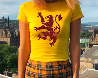 May include: A yellow t-shirt with a red glitter lion design. The lion is a heraldic symbol.
