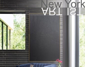 May include: A blue velvet armchair with a cat sitting on the seat. The chair is in a room with a black and white abstract painting on the wall, a small side table, and a white rug on the floor.