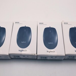 May include: Four Logitech B100 full-size wired computer mice in their original packaging. The mice are dark blue and have a simple, ergonomic design. The boxes are white with the Logitech logo and product information.