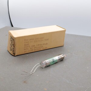 May include: A vintage electronic tube with a clear glass body and metal components, next to a tan cardboard box. The box has printed text including "ONE PA ELECTRON TUBE" and "Mfg. by Sylvania". The tube has two wire leads.
