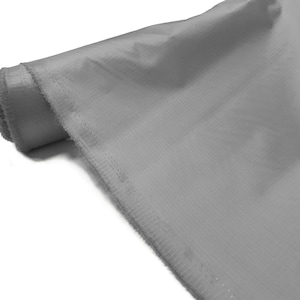 May include: A roll of light gray fabric with a subtle texture. The fabric has a finished edge.