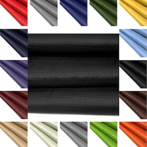 May include: A variety of colors of fabric with a grid pattern. The fabric is folded in thirds and the folds are visible. The fabric is a woven material with a smooth texture.