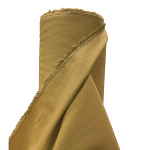 May include: A roll of mustard yellow fabric with a raw edge. The fabric is folded over and the raw edge is visible.