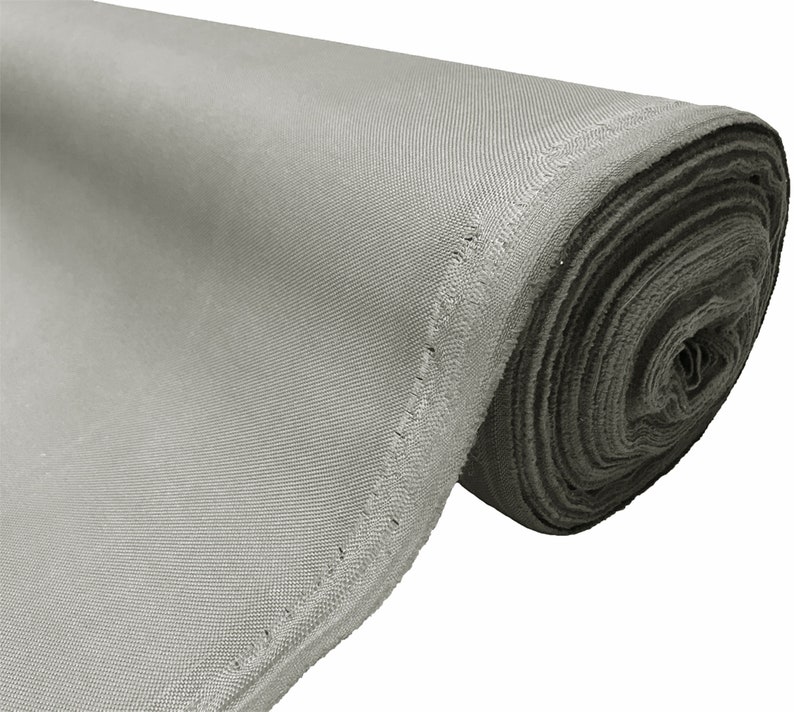 May include: A roll of gray fabric with a stitched edge. The fabric is rolled up tightly and the end of the roll is visible.