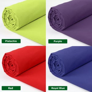 May include: Four rolls of fabric in vibrant colors: pistachio green, purple, red, and royal blue. Each roll is labeled with its respective color name. The fabric is tightly rolled, showcasing the smooth texture and rich hues.