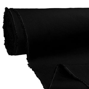 May include: A roll of black fabric with a raw edge. The fabric is tightly rolled and has a smooth texture.