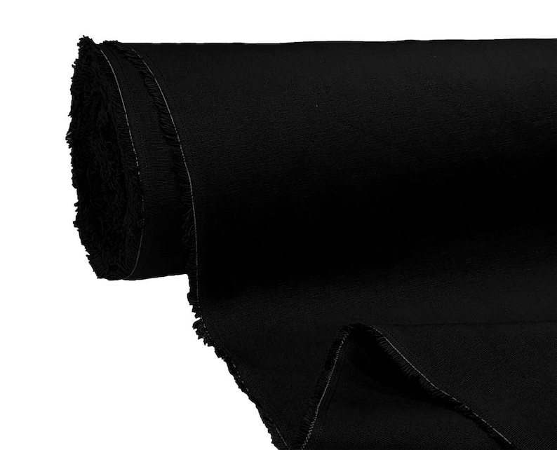 May include: A roll of black fabric with a raw edge. The fabric is tightly rolled and has a smooth texture.