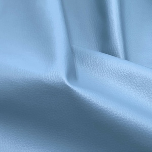 May include: A close-up of a light blue textured fabric. The fabric is smooth and has a subtle sheen.