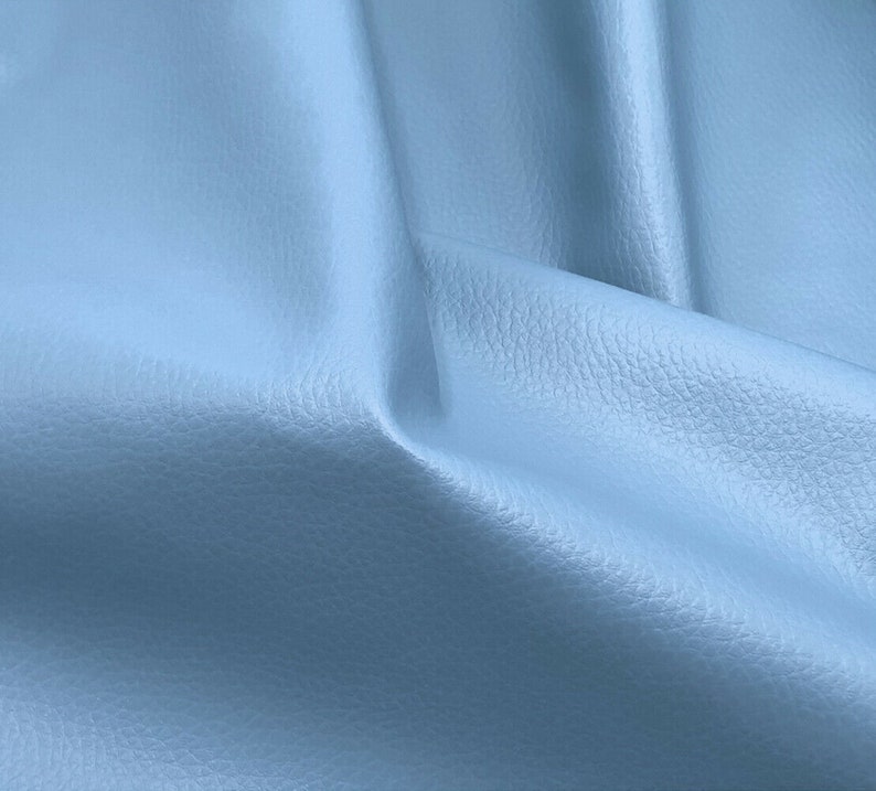 May include: A close-up of a light blue textured fabric. The fabric is smooth and has a subtle sheen.