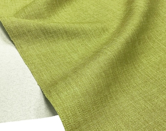 May include: A close-up of a textured green fabric. The fabric has a subtle sheen and a woven pattern.