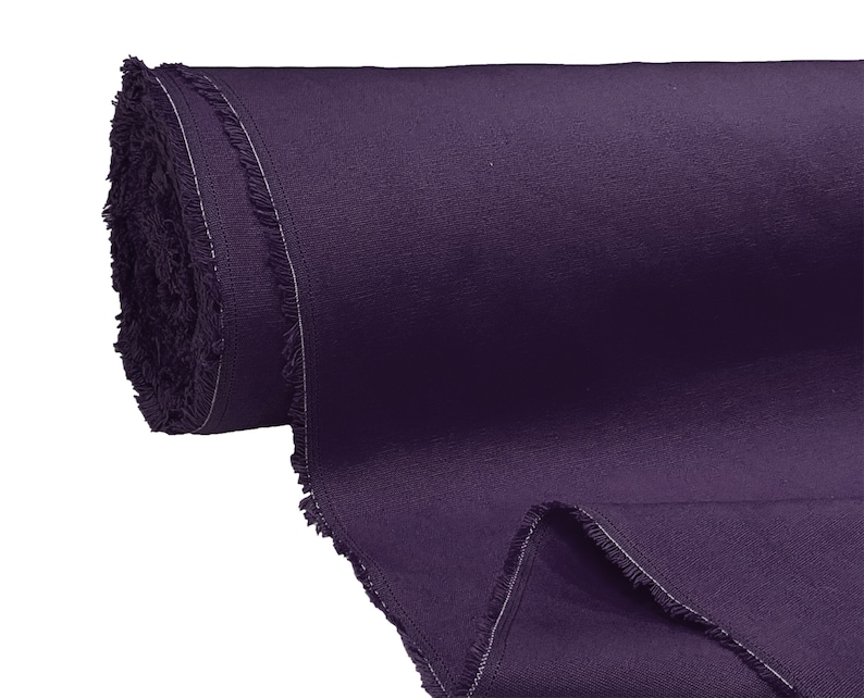 May include: A roll of dark purple fabric with a raw edge. The fabric is tightly rolled and has a soft, textured surface.