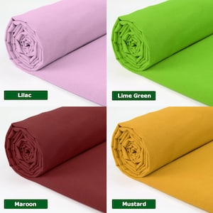 May include: Four rolls of fabric in different colors: lilac, lime green, maroon, and mustard. Each roll is tightly wound, displaying the fabric's texture. The color names are displayed in green rectangles below each roll.