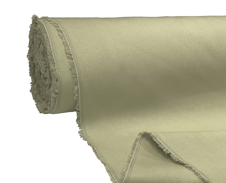 May include: A roll of light green fabric with a raw edge. The fabric is rolled up and has a fringed edge.