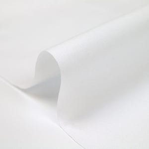 May include: White fabric with a smooth, even texture. The fabric is folded over, creating a soft curve.