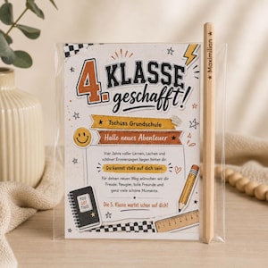 Könnte beinhalten: Ein in Zellophan verpacktes Karten- und Bleistiftset. Die Karte trägt die Aufschrift "4 Klasse geschafft!" mit Text und Illustrationen. Ein Bleistift aus Holz mit der Aufschrift "Maximilian" ist enthalten. Das Thema ist der Schulabschluss.
