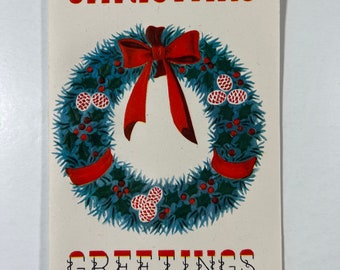 May include: A vintage Christmas greeting card with a red and green wreath with a red bow. The card has the text "CHRISTMAS GREETINGS" in black with red and yellow accents.