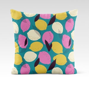 May include: Square throw pillow with a teal background and a repeating pattern of stylized lemons in yellow, pink, and off-white. The lemons have black dotted details and dark purple leaf accents. A decorative accent for a sofa or bed.