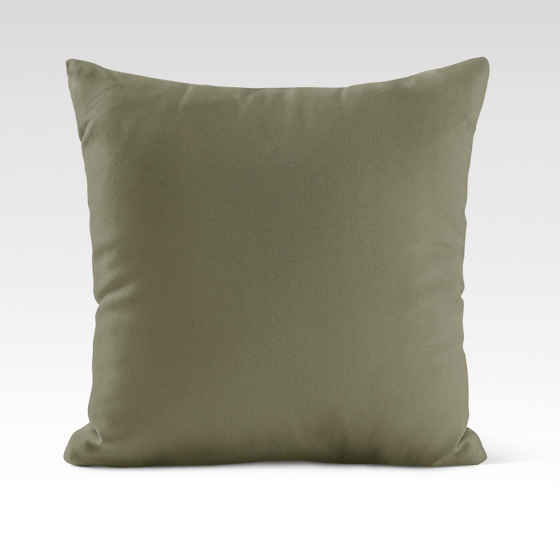 Op de afbeelding: Een vierkant, effen groen kussen met een zachte, pluche textuur.