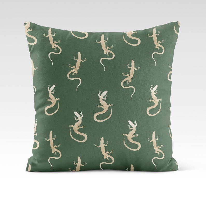 May include: A green throw pillow with a repeating pattern of beige lizards. The lizards are facing different directions and are in various poses.