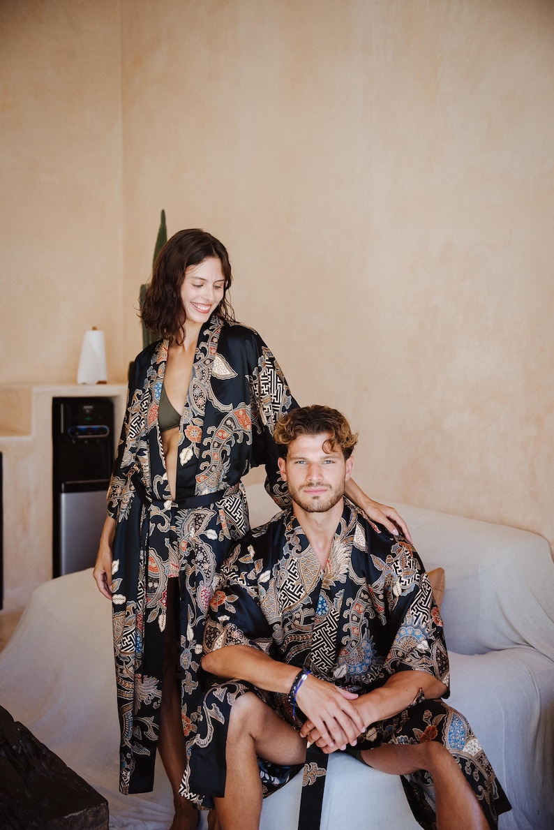 May include: A couple wearing matching black and gold patterned robes with intricate designs. The robes have a traditional Japanese style.