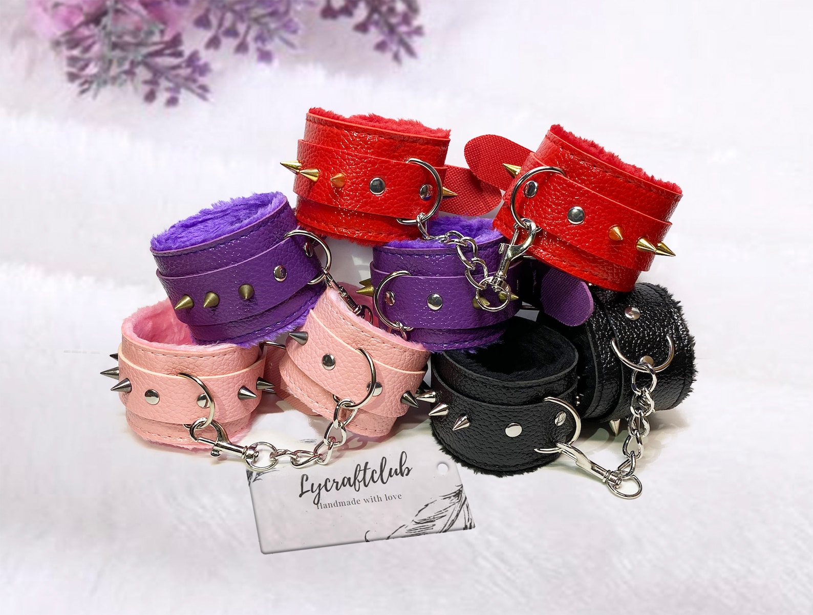 Colorful spiked faux leather furry BDSM cuffs in pink, purple, red, and black for bondage restraints and tie-up sex.