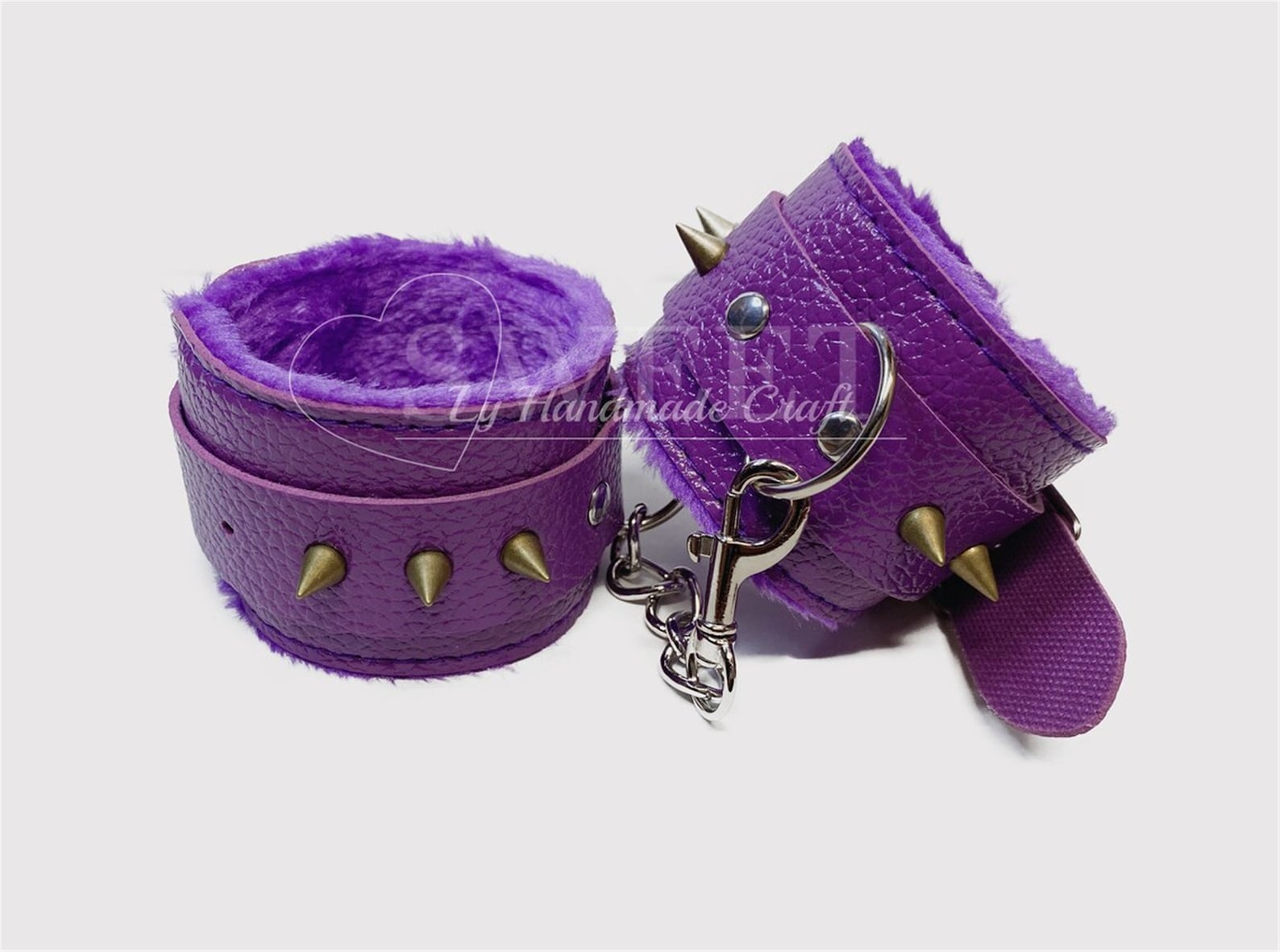 Purple spiked faux leather bondage cuffs with plush lining, edgy BDSM restraints for restraint sex and tie-up play.