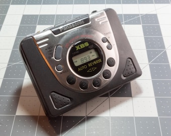 May include: A silver and black Panasonic cassette player with a digital display showing "893" and the text "XBS AUTO REVERSE".