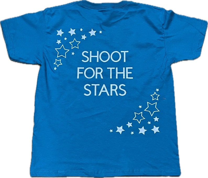 May include: A bright blue t-shirt with a white graphic that says "Shoot for the Stars" and a design of white stars.