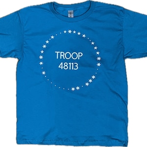 May include: A turquoise blue t-shirt with a white circle design featuring a ring of stars and the text "TROOP 48113".
