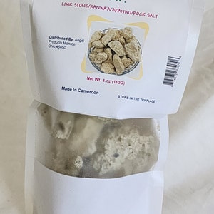 May include: A white resealable bag with a label that reads "A.P. LIME STONE/KANWA'A/AKANWU/ROCK SALT" and "Net Wt. 4.oz (112G)". The bag contains a white rock-like substance.