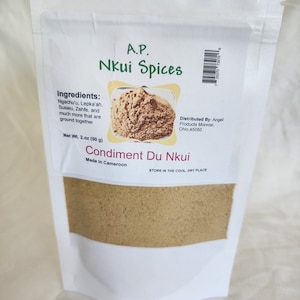 Könnte beinhalten: Ein weißer wiederverschließbarer Beutel mit braunem Pulver darin. Der Beutel ist mit "A.P. Nkui Spices" und "Condiment Du Nkui" beschriftet. Die Zutaten sind aufgelistet als "Ngachu'u, Lepka'ah, Susieu, Zehfe und vieles mehr, das zusammen gemahlen wird". Der Beutel wird in Kamerun hergestellt und hat ein Nettogewicht von 50 Gramm (2 Unzen).