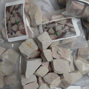 May include: Multiple bags of white clay chunks, labeled "Angel Products" and "100% Natural".