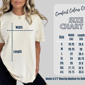 May include: A cream-colored short-sleeve t-shirt with a Comfort Colors C1717 size chart. The chart lists widths and lengths in inches for sizes S through 4XL, noting a model height of 5'2" wearing a size medium for reference and visual scale.
