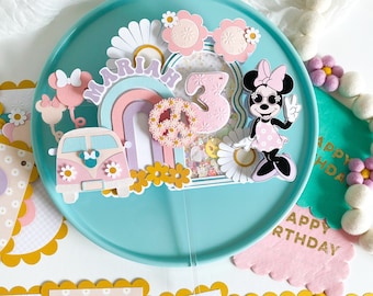 Peut inclure: Une bannière d'anniversaire de couleur pastel avec les lettres "Joyeux anniversaire" et un van rose et blanc avec des fleurs. La bannière est décorée de marguerites et d'un arc-en-ciel.