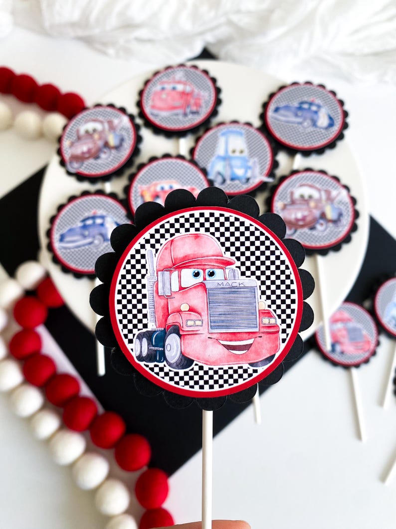 Puede incluir: Un conjunto de 10 adornos para cupcakes rojos, negros y blancos con personajes de la pel&iacute;cula Cars. Los adornos presentan un dise&ntilde;o de bandera a cuadros y im&aacute;genes de Rayo McQueen, Mate y otros personajes de Cars. Los adornos son perfectos para una fiesta de cumplea&ntilde;os con tem&aacute;tica de Cars.