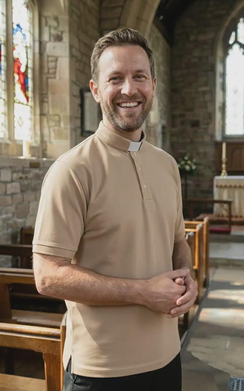 Op de afbeelding: Een beige poloshirt met korte mouwen, voorzien van een opstaande kraag en een wit priesterboordje bij de halslijn. Het shirt heeft een knoopsluiting, een rechte zoom met zijsplitten en een gladde stoftextuur voor formele religieuze kleding.
