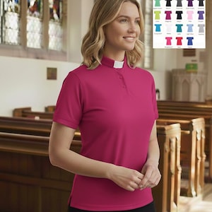 May include: A short-sleeved magenta clergy shirt featuring a standing collar with a white tab insert and a button-down placket. The shirt is displayed alongside a color chart showing various available shades including mint, black, charcoal, purple, lime, pink, navy, white, turquoise, light blue, heather, raspberry, red, and royal.