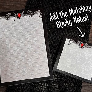 May include: A lined notepad and sticky note set with a black border and ornate silver and red accents. The notepad and sticky note have a white background with a subtle floral pattern. Text in the image reads "Add the Matching Sticky Notes!"