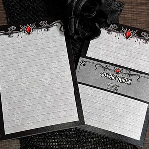 May include: Two memo pads with a black border and a decorative top design featuring a red gem. The pads have lined pages with a subtle floral pattern. One pad is labeled "Gothic Queen" with "Memo Pad 50 Sheets".