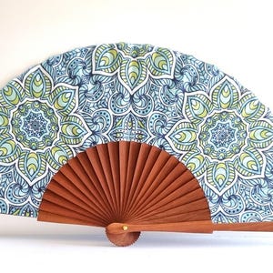 A hand fan made of wood and fabric, with a geometric design, handmade in Spain. Ideal for everyday use.